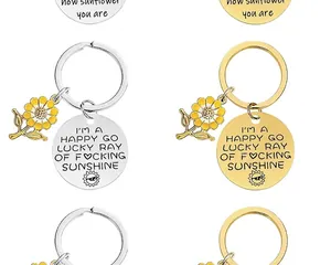 Detailed view of sunflower charm keychains with engraved inspirational quotes on metal tags