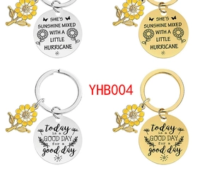 Detailed view of four metal sunflower keychains in gold and silver with engraved quotes