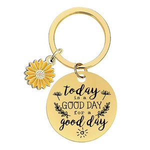 Golden sunflower keychain with an engraved inspirational quote on a round metal plate