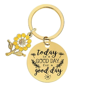 Golden sunflower keychain with engraved inspirational round tag on white background