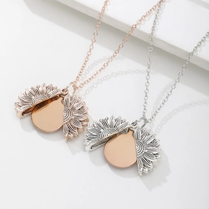 Detail of opening sunflower locket pendant revealing a polished engravable gold disc