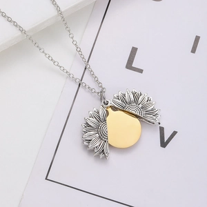 Close-up of a two-tone sunflower locket necklace with an openable silver and gold pendant