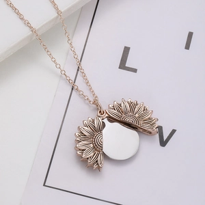 Macro detail of rose gold sunflower locket opening to reveal a customizable round disc