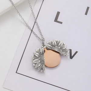 Detail of vintage sunflower locket pendant opening to reveal rose gold inner disc
