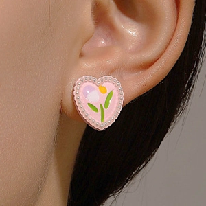Detailed macro view of heart-shaped pink tulip earring with white pearl border