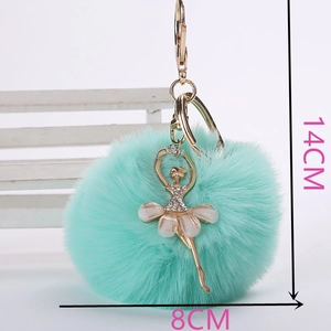 Vue détaillée du pompon vert menthe en fausse fourrure avec pendentif ballerine