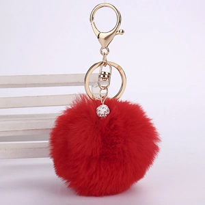 Macro detail of red faux rabbit fur pom pom keychain with sparkling crystal pave ball