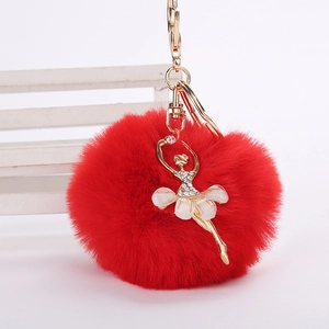 Détail du porte-clés pompon en fausse fourrure rouge avec ballerine en cristal dorée