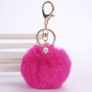 Detail of soft rose red faux fur keychain with a gold clasp and sparkling crystal ball