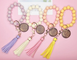 Détail de porte-clés en perles de silicone avec pendentif MAMA et pompon en cuir