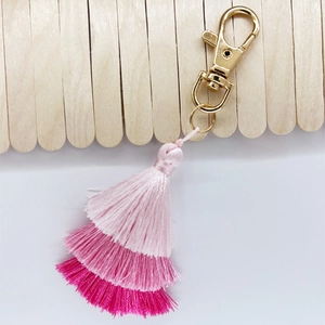 Detailed view of three-tier gradient pink cotton tassels with golden metal lobster clasp