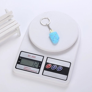 Creative blue ice cream keychain showing detailed weight of 12g on an electronic scale