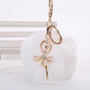 Détail du pompon en fausse fourrure blanche avec poupée ballerine dorée et strass