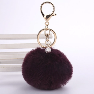 Detail view of burgundy faux rabbit fur pompom keychain with sparkling crystal pave ball