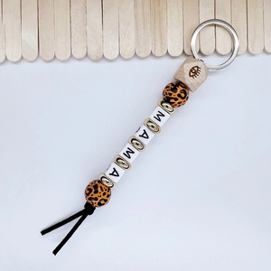 Detail of handmade beaded keychain featuring leopard print and MAMA white letter beads