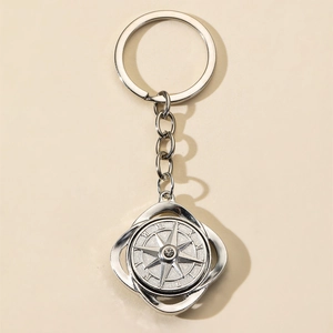 Close-up of rotatable alloy compass keychain with crystal inlay and Roman numerals