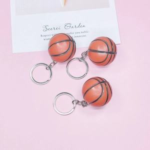 Detailed view of three orange basketball keychains with textured surface and silver rings