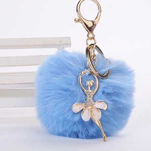 Détail du pompon en peluche bleu clair avec pendentif ballerine en strass et porte-clés doré