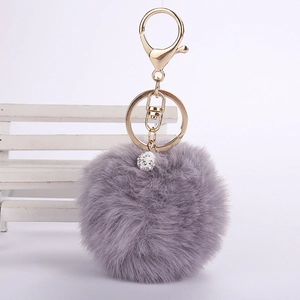 Close-up of grey faux rabbit fur keychain with gold lobster clasp and rhinestone ball
