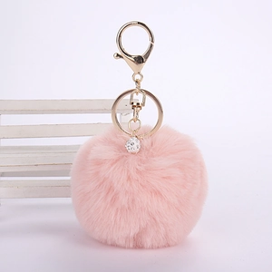Detail of pink faux rabbit fur keychain with gold alloy ring and sparkling crystal ball