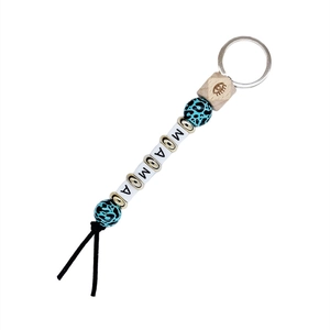 Detail of wooden mama keychain with leopard print beads and evil eye symbol engraved
