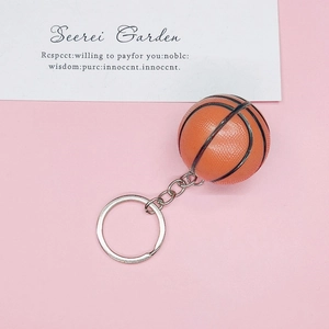 Detail view of orange basketball keychain with realistic texture and silver metal ring
