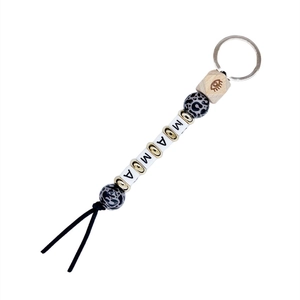 Detail of beaded keychain featuring leopard print wood beads and white MAMA letter beads