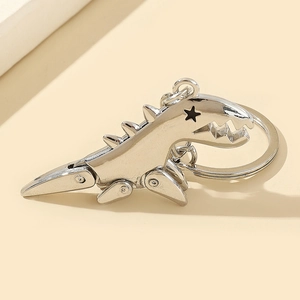 Close-up of silver alloy T-Rex keychain with movable joints and star-shaped eye detail