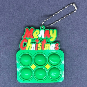 Dettaglio del portachiavi Pop It natalizio verde con testo Merry Christmas e bolle tattili