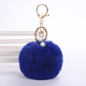 Detailed view of dark blue faux fur keychain with sparkling rhinestone ball and gold clip