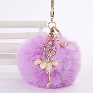 Détail du porte-clés pompon en fausse fourrure fuchsia avec breloque ballerine dorée
