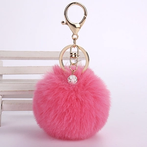 Detail of pink faux rabbit fur keychain with sparkling rhinestone ball and gold clasp