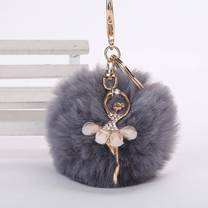 Détail du porte-clés pompon en fausse fourrure grise avec ballerine en strass et clip doré