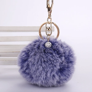 Detailed view of purple faux rabbit fur pom pom keychain with gold lobster clasp and rhinestones