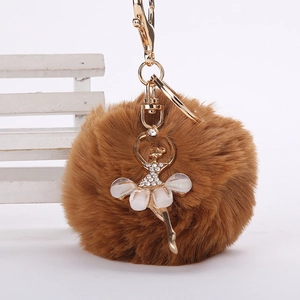 Détail de porte-clés en fausse fourrure marron avec pendentif danseuse en cristal