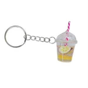 Fruit bubble tea cup keychain with lemon slice and liquid filling on white background