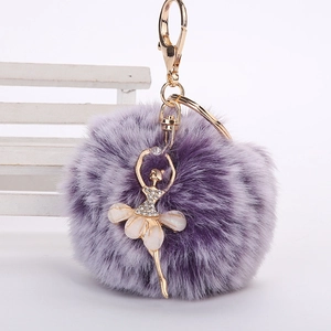 Détail d'un porte-clés en fausse fourrure violette avec pendentif ballerine dorée et strass