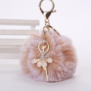 Détail de porte-clés pompon en fausse fourrure rose avec breloque danseuse en strass