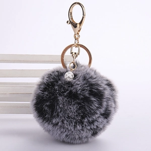 Detail of soft faux rabbit fur pom pom keychain with gold clasp and crystal bead accessory