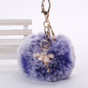 Détail d'un porte-clés pompon violet en fausse fourrure avec ballerine dorée
