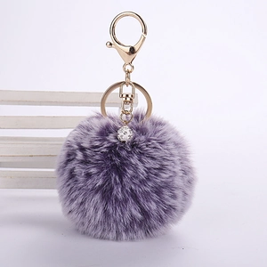 Detail of lavender faux rabbit fur pom pom keychain with gold lobster clasp and crystal ball