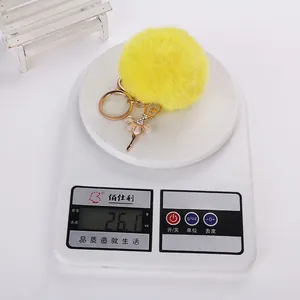 Mesure du poids d'un porte-clés en peluche jaune avec breloque ballerine strassée