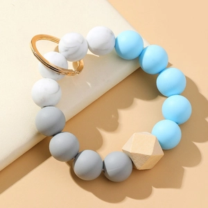 Détail du bracelet porte-clés en perles de silicone avec marbre et perle géométrique en bois