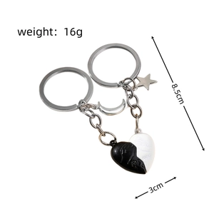 Macro detail of magnetic heart keychains with moon and star charms and Forever engraving