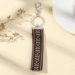 Detail of ethnic geometric woven strap keychain with silver metal lobster clasp and ring
