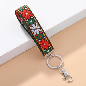 Detailed embroidery of floral pattern on green ethnic lanyard with silver lobster clasp