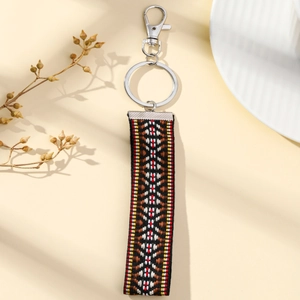 Close-up of geometric ethnic floral embroidery on a colorful woven fabric keychain strap