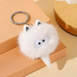 Close-up of a white plush monster keychain with large eyes and ice cream cone base
