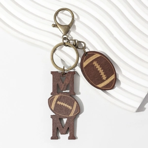 Creative wooden MOM keychain with American football charm and bronze hook on white surface