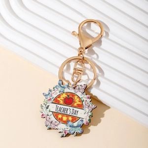 Rainbow teacher's day keychain with sunflower, butterfly and apple charm on white stand
